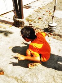 High angle view of girl sitting outdoors