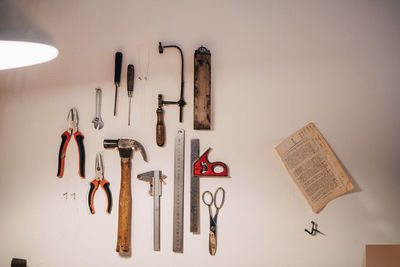 Various work tools hanging on wall at workshop