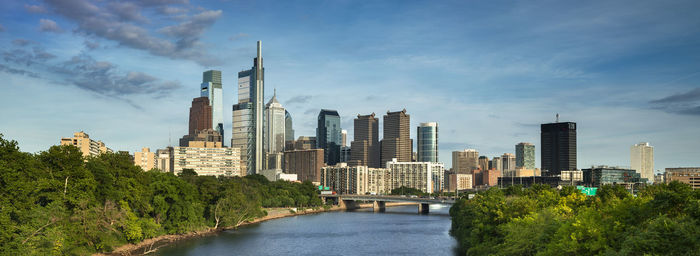 River amidst buildings in city against sky