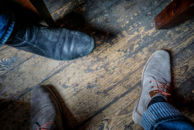 Low section of man standing on wooden floor