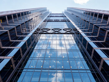 Low angle view of modern glass building against sky