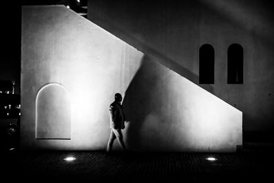 Silhouette man and woman standing by illuminated building