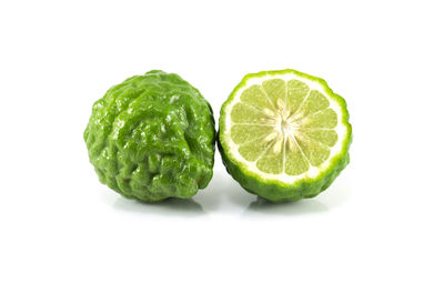 Close-up of green fruit against white background