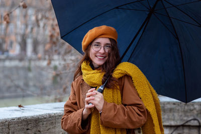 Girl walks in the city. young woman in winter dress and umbrella, she walks on a cold winter day.