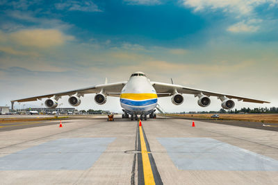 Airplane on runway against sky