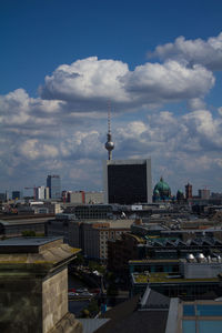 Buildings in city against cloudy sky