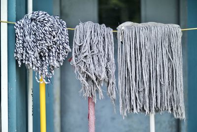 Various mops hanging on rope against building