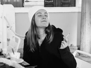 Portrait of young woman smoking cigarette