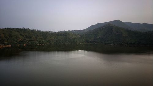 Scenic view of lake and mountains against clear sky