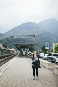 Woman taking photos on train station