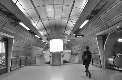 Rear view of person walking in subway station