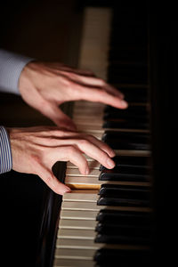 Cropped image of person playing piano