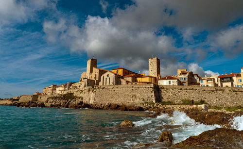 Panoramic view of sea and buildings against sky