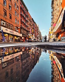 Canal by buildings against sky in city