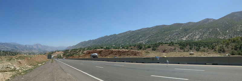 Road by mountain against clear sky