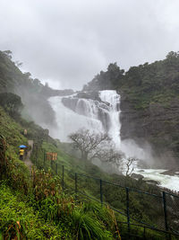 Scenic view of waterfall against sky