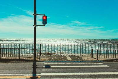 Road by sea against blue sky