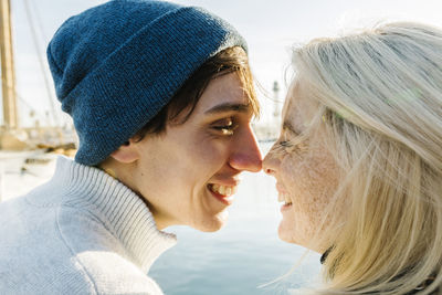 Smiling young couple face to face at harbor