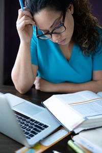 Midsection of woman using mobile phone while sitting on table