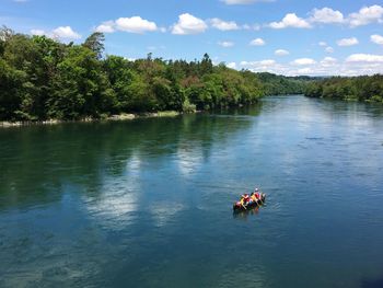 People in lake against sky