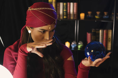 Female fortune teller with crystal ball at home