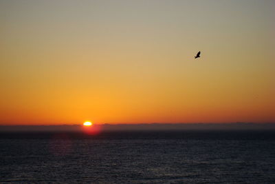 Scenic view of sea against orange sky