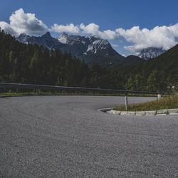 Road by mountains against sky