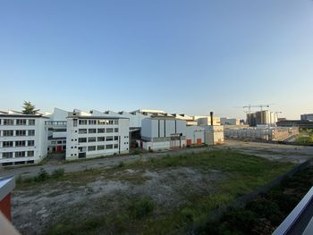 Buildings in city against clear blue sky