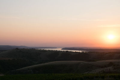 Scenic view of land against sky during sunset