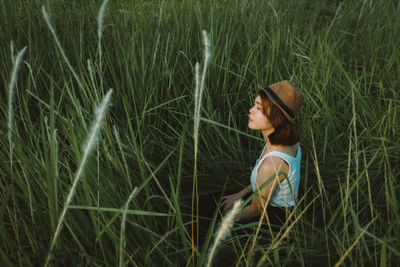 Woman amidst grass on field