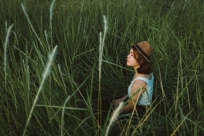 Side view of woman looking away on field