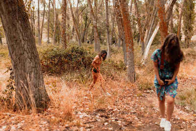 Lesbian couple walking on trail in forest