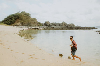 Full length of man on beach against sky