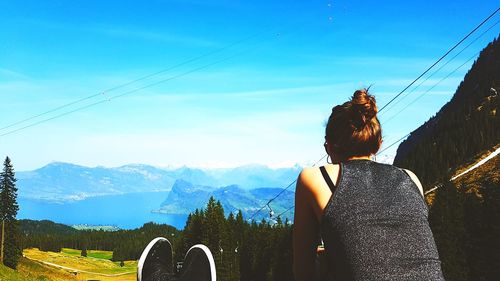 Rear view of man looking at mountain range against sky