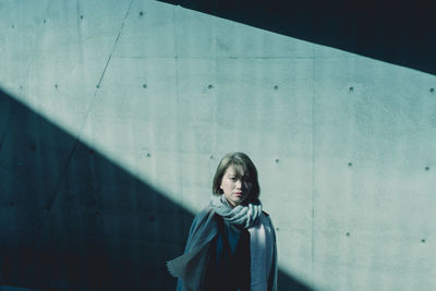 Portrait of woman standing against wall