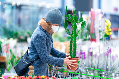 Midsection of woman standing by flower pot