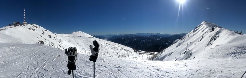 Panoramic view of snowcapped mountains against clear blue sky