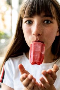 Portrait of girl licking flavored ice