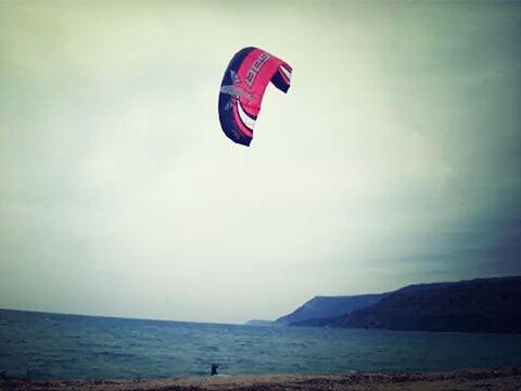 sea, beach, sky, scenics, horizon over water, tranquility, tranquil scene, water, shore, parachute, beauty in nature, sand, vacations, nature, flying, mountain, mid-air, paragliding, sport, cloud - sky