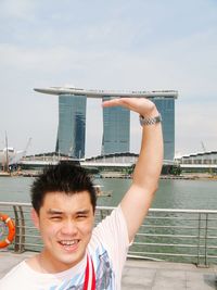 Optical illusion of man touching marina bay sands