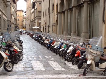 Motor scooters parked by buildings