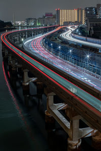 Light trails on bridge over river at night