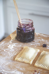 Close-up of preserves in jar by ravioli on table