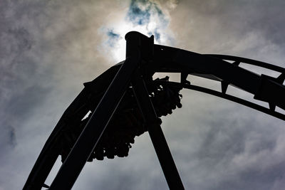 Low angle view of silhouette rollercoaster against sky