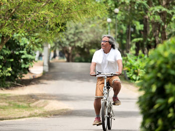 Mature man riding bicycle on road