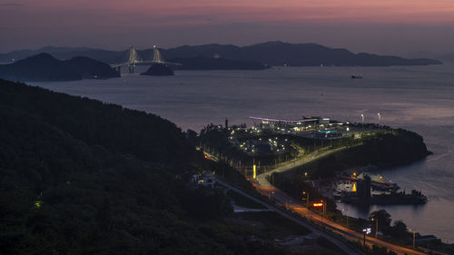 High angle view of illuminated bay against sky at sunset