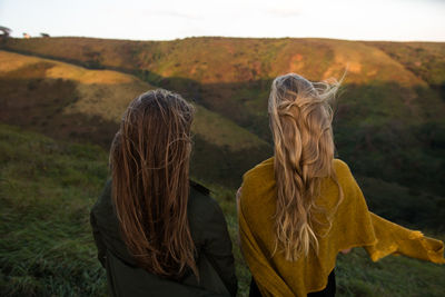 Rear view of women standing on field