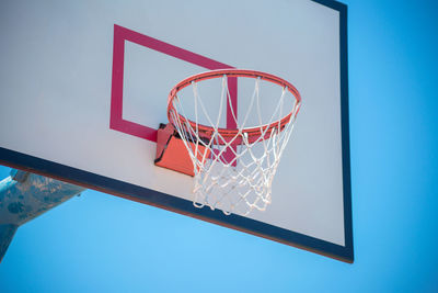 Low angle view of basketball hoop against blue sky