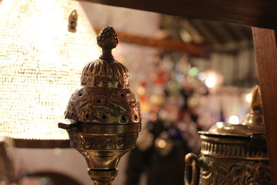 Close-up of illuminated lamp on table in temple