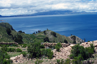 Scenic view of sea and mountains against sky